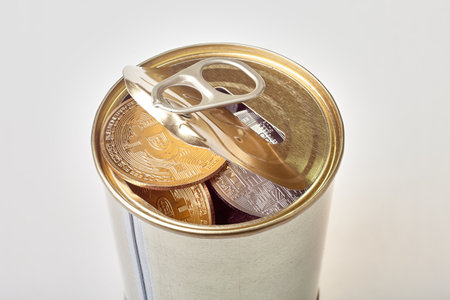 Bitcoin in a tin can. A coin in a tin can on a white background.の写真素材