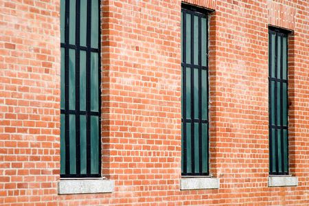 Three windows in old restored red brick building.の写真素材