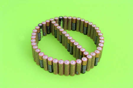 Group of standing batteries forming the universal DON'T SYMBOL to prevent improper disposal of old...