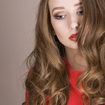beautiful young woman. Healthy hair girl with make-up.Lady in redの写真素材