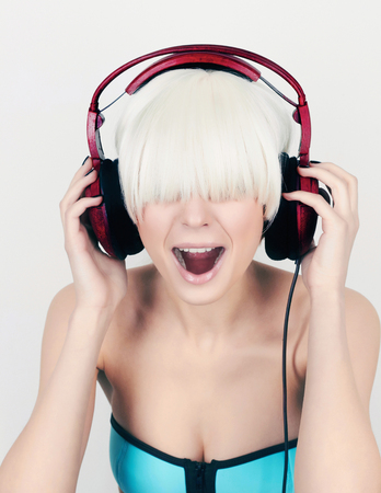 screaming girl in headphones.fashion portrait of beauty Woman listening music on headphones.beautiful girl with bob hairstyle.Screamの写真素材