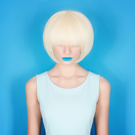 beautiful young woman with blue lips. bob hairstyle girl.blue backgroundの写真素材