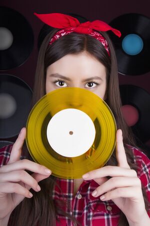 Young woman with vinyl disc.Retro Disco.simple girl in shirt.vinyl backgroundの写真素材