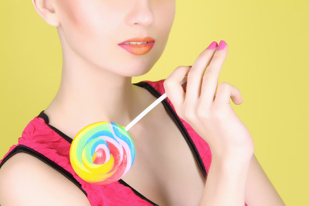 girl with A Lollipop.Fashionable young woman with make-up holding a candyの写真素材