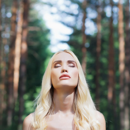 Beautiful Blond girl in Forest. Summer Beauty blonde young womanの写真素材