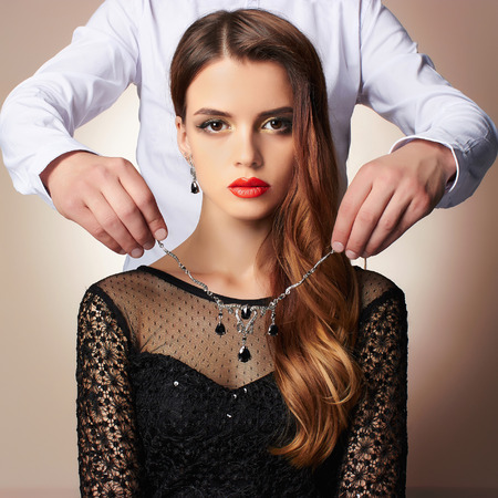 Fashion photo of elegant couple.a man gives a beautiful woman expensive jewelryの写真素材