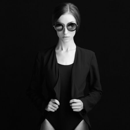 Studio fashion monochrome photo of beautiful stylish woman in sunglasses. pretty young model girlの写真素材