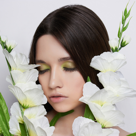 beautiful teen girl with white flowers.tenderness spring beauty young womanの写真素材