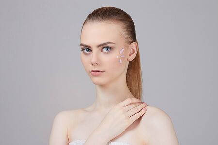 beauty young woman cares for face skin.beautiful girl with cosmetic cream on a clean fresh face....