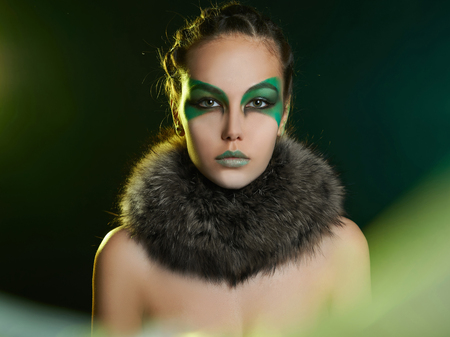 fantasy woman in fur and green make-up.fairy beautiful girl in moonlight.barbarian who lives in the woodsの写真素材