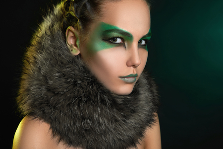 fantasy woman in fur and green make-up.fairy beautiful girl.barbarian who lives in the woodsの写真素材