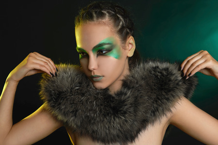 fantasy woman in fur and green make-up.fairy beautiful girl.barbarian who lives in the woodsの写真素材