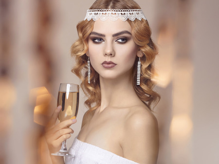 Luxury Beautiful young woman with champagne at the party.beauty girl in event dress.make-up and...