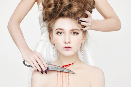 Halloween murder.Beautiful young woman kills knife.two girls and blood.unusual isolated portrait.stylish killingの写真素材