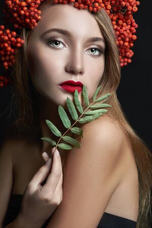 Autumn Woman Fashion Portrait. Beautiful Model Girl with autumn red berries hairstyleの写真素材