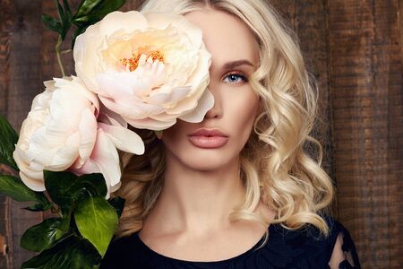 fashion portrait of beautiful blond girl with big white flower.beauty young woman