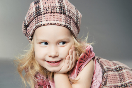funny little girl in hat. smiling child girl posing in studioの写真素材
