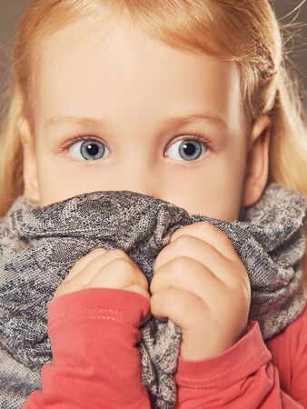 sad little girl in scarf.children fearの写真素材