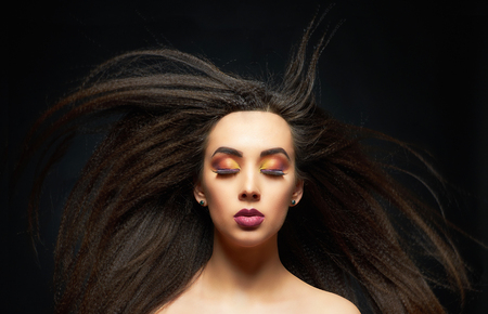 fashion portrait of beautiful make-up woman with flying hair.beauty make up girl.colorful eye shadowの写真素材