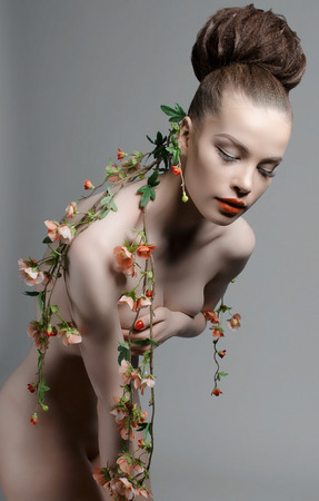 sexy nude beautiful woman in flowers.fashion art photo of perfect body model girl with make-up and hairstyle.spring lady plantの写真素材
