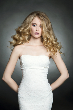 sexy Blonde girl with healthy wavy hair. Beautiful young woman with curly hairstyle and make upの写真素材