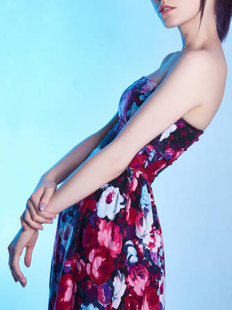 Beauty Girl in flower dress.young Woman over blue backgroundの写真素材