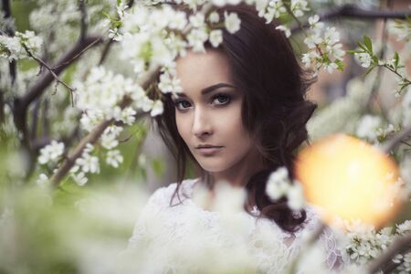 Beautiful girl in Forest.Beauty young woman in Apple-tree flowersの写真素材