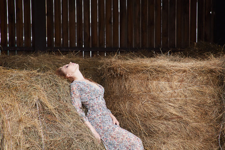 Beautiful girl in the hayloft.Village provincial woman In the hayの写真素材