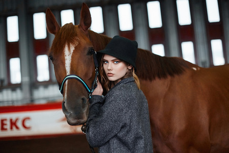Beautiful girl in hat walking with a horse.beauty young woman and horse