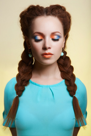 beauty girl with braids hairstyle. beautiful young woman with colorful make-upの写真素材