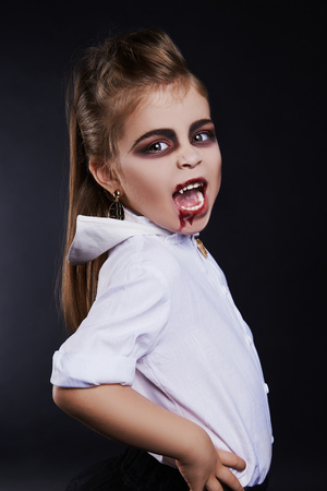 little vimpire child.girl with halloween make-up.dracula kid with blood on her face.halloween childrenの写真素材