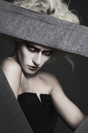 halloween style girl with white skin and hair with clown make-up posing in the studio.psycho woman imageの写真素材