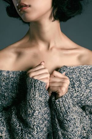 sexy young woman dressed in a knitted sweater.brunette model girl posing in studioの写真素材