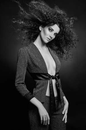 beautiful young woman with curly hair. beauty sexy girl in suit, black and white portrait. Salon hairstyleの写真素材