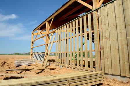 Normandiy, France, May 2013.
Construction of a new farm building for cows breeding with wood frame and  wood siding. Installation of the timber frame.のeditorial素材