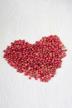 Dried rose pepper in shape of heart on a tableの写真素材