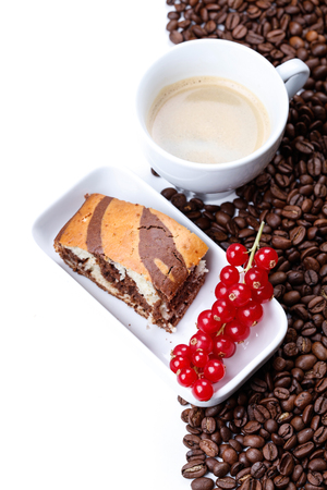 Marble cake pieces with red currant on white background with a cup of coffeeの写真素材