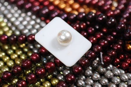 white pearl on top of colorful freshwater pearl strandsの写真素材
