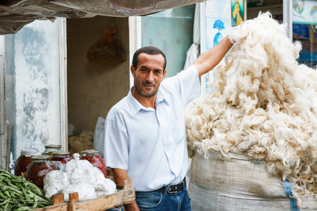 SHEKI, AZERBAIJAN - 20 July 2015: portrait of male seller sheep's wool looking at camera in authentic causaian outdoor marketのeditorial素材