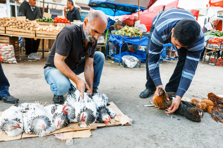 SHEKI, AZERBAIJAN - 20 July 2015: portrait of male seller chiken looking at camera in authentic causaian outdoor marketのeditorial素材