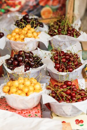 colorful yellow, red, dark Cherries on a market counterの写真素材