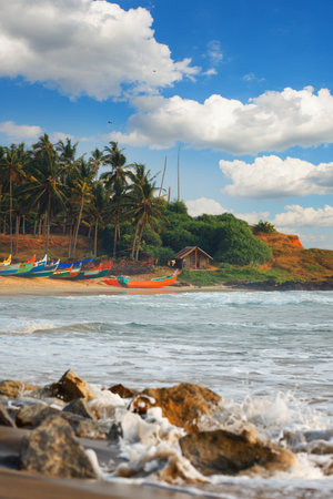 Beautiful peaceful black beach with houses and boats in Varkala, Odayam fishermen village Kerala, Indiaのeditorial素材