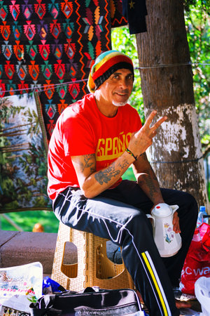 Tbilisi, Georgia - 08 October, 2016: An unidentified rastafari seller on Dry Bridge Flea market in Tbilisi sells Soviet badges and icons, retro junk stuff, tableware set, dishesのeditorial素材