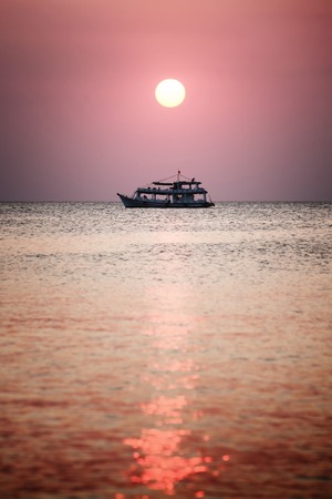 Sunset at the beach of Phu Quoc, sun disk beam reflection on sea ocean waterの写真素材