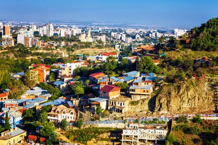 Tourustic ride on the funicular, aerial view from the top of cockpit on the roofs of the old city of Tbilisi: houses with traditional wooden carving balconies, famous Georgian architecture of Old Town of Tbilisi, Georgiaの写真素材