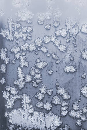 incredibly beautiful patterns are drawn by a frost on the windows of houses, blue tintの写真素材