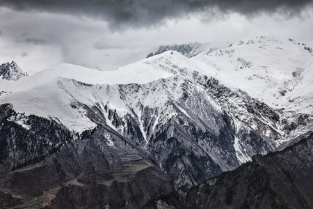 Dramatic Panoramic view on snow winter mountains and sunlight cloud sky in evening. Caucasus...