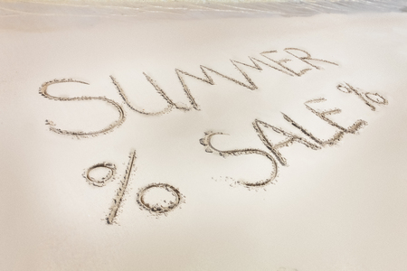 The Summer sale letters word written on the beach sand. Crystal blue water of the seaの写真素材