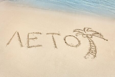 The Summer letters word written in Russian and palm tree icon on the beach sand. Crystal blue water of the seaの写真素材