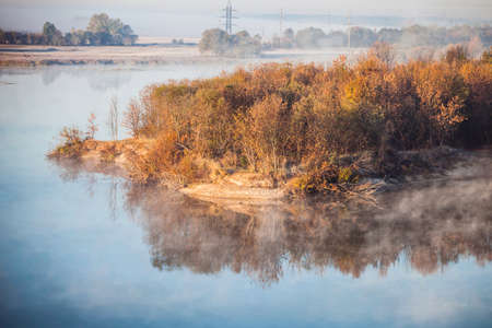 Misty forest and fog along the river Sozh, Gomel, Belarus on the sunrise morning in the autumnの写真素材